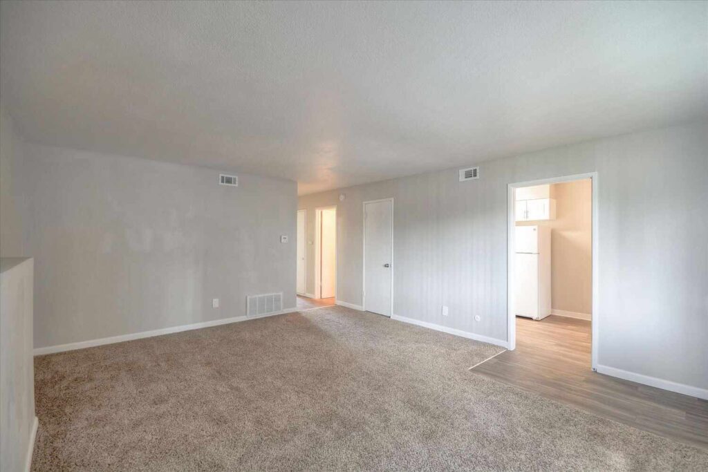 Carpeted living space with door to the kitchen